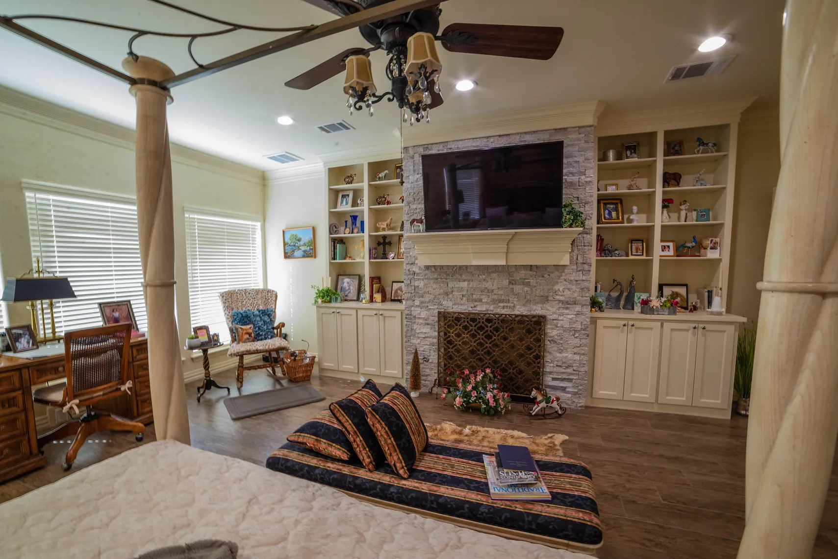 Primary suite sitting area with stone fireplace and built-ins