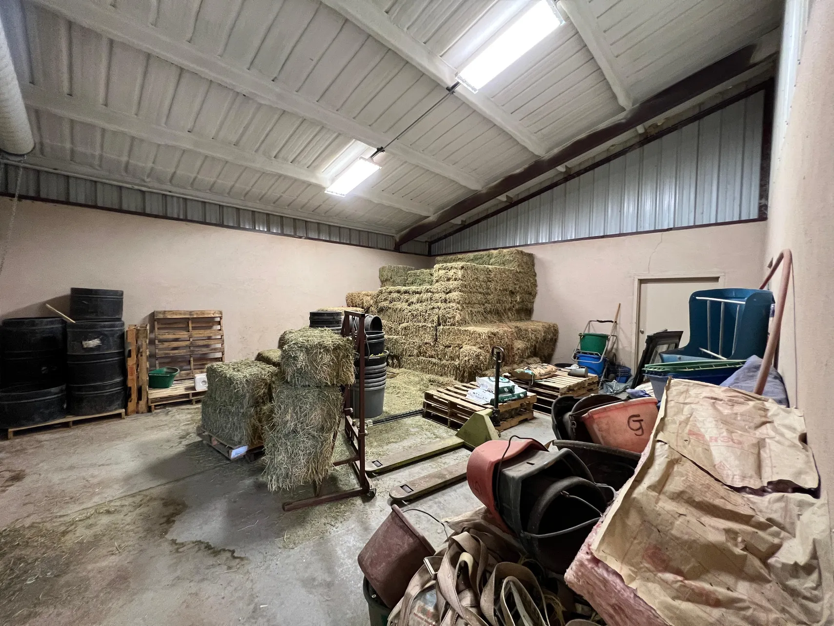 Barn feed and hay storage room with pallets and tack