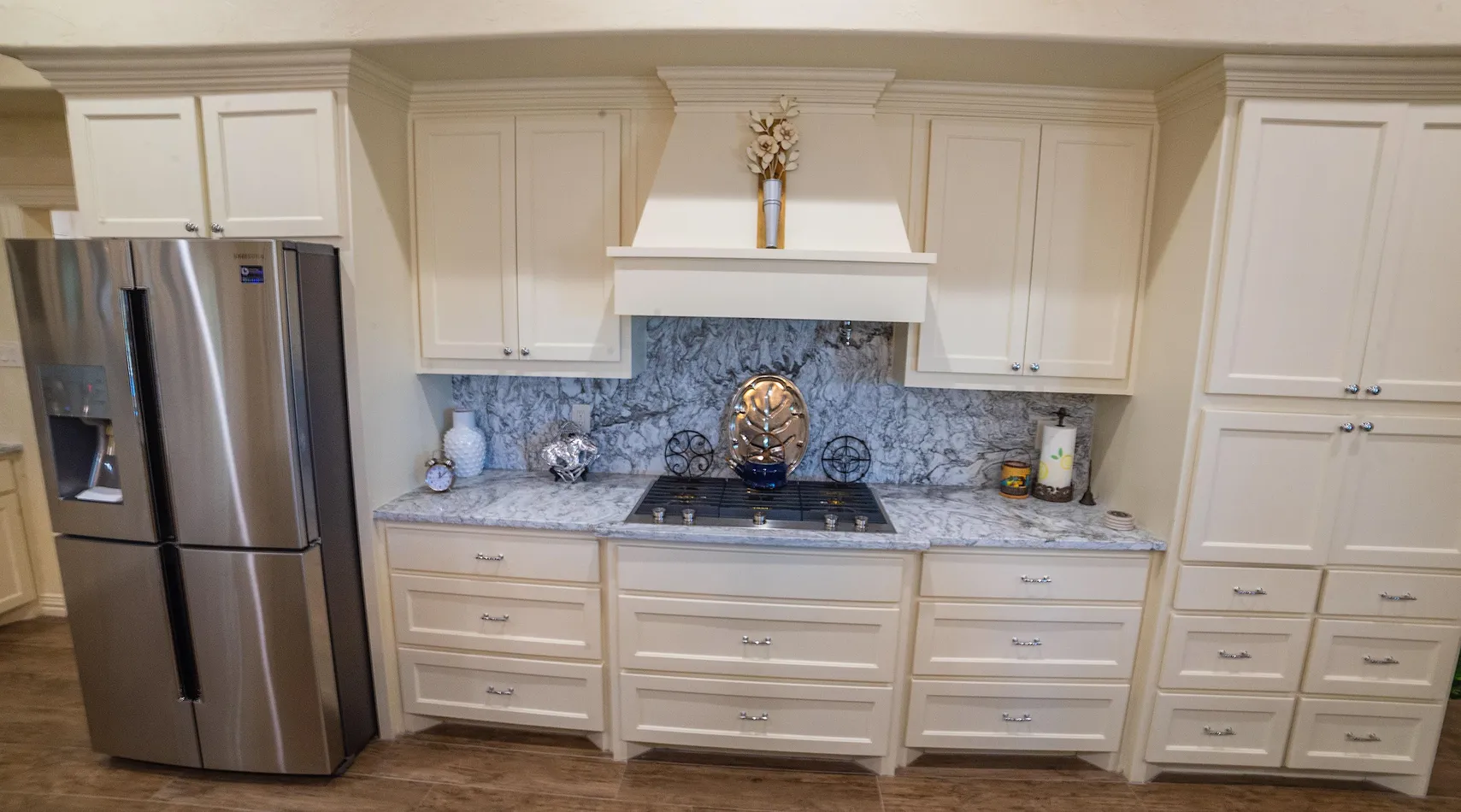 Gas cooktop with marble backsplash and custom cabinetry