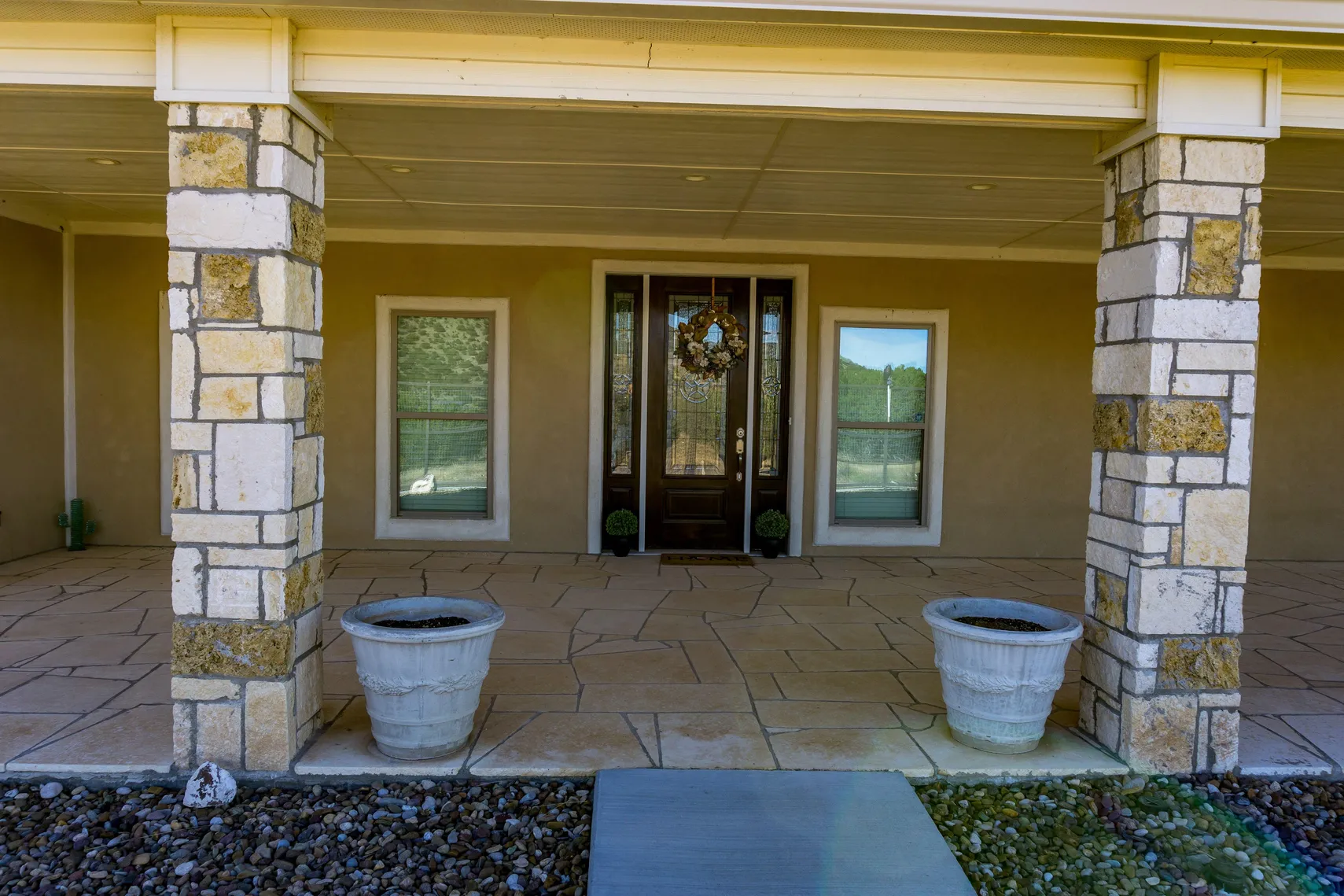 Front entry with stone columns and custom wood door