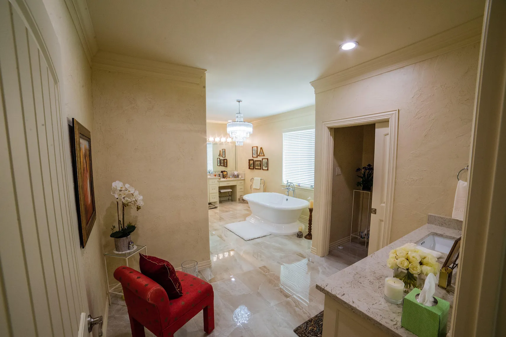Primary bath entry with marble floors and soaking tub beyond